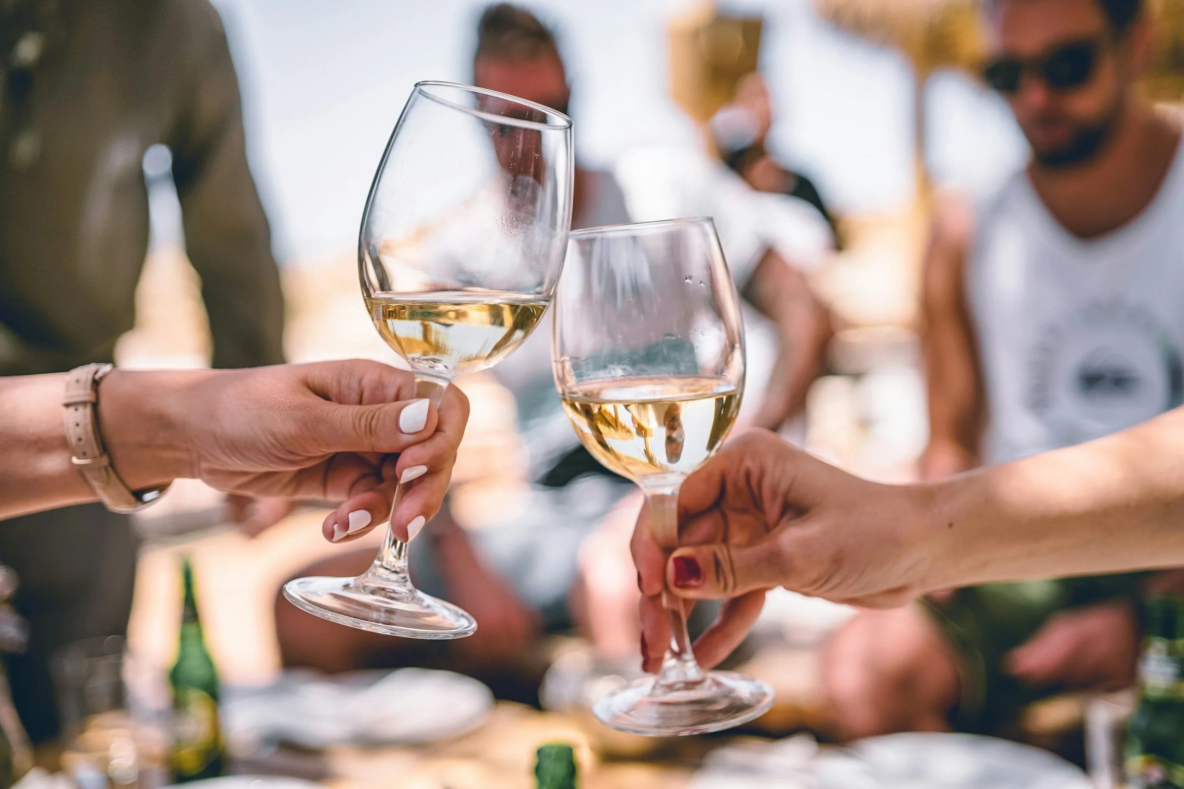 Two glasses of Spanish white wine raised in a toast under the Sitges sun